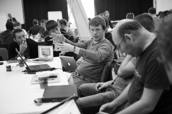 catch speaking and gesturing at a table of contributors