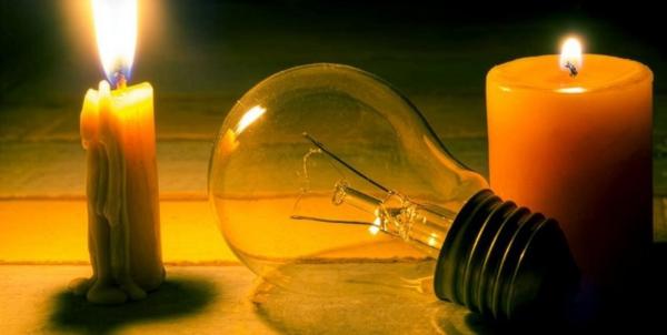 Two lit candles and a disconnected light bulb.